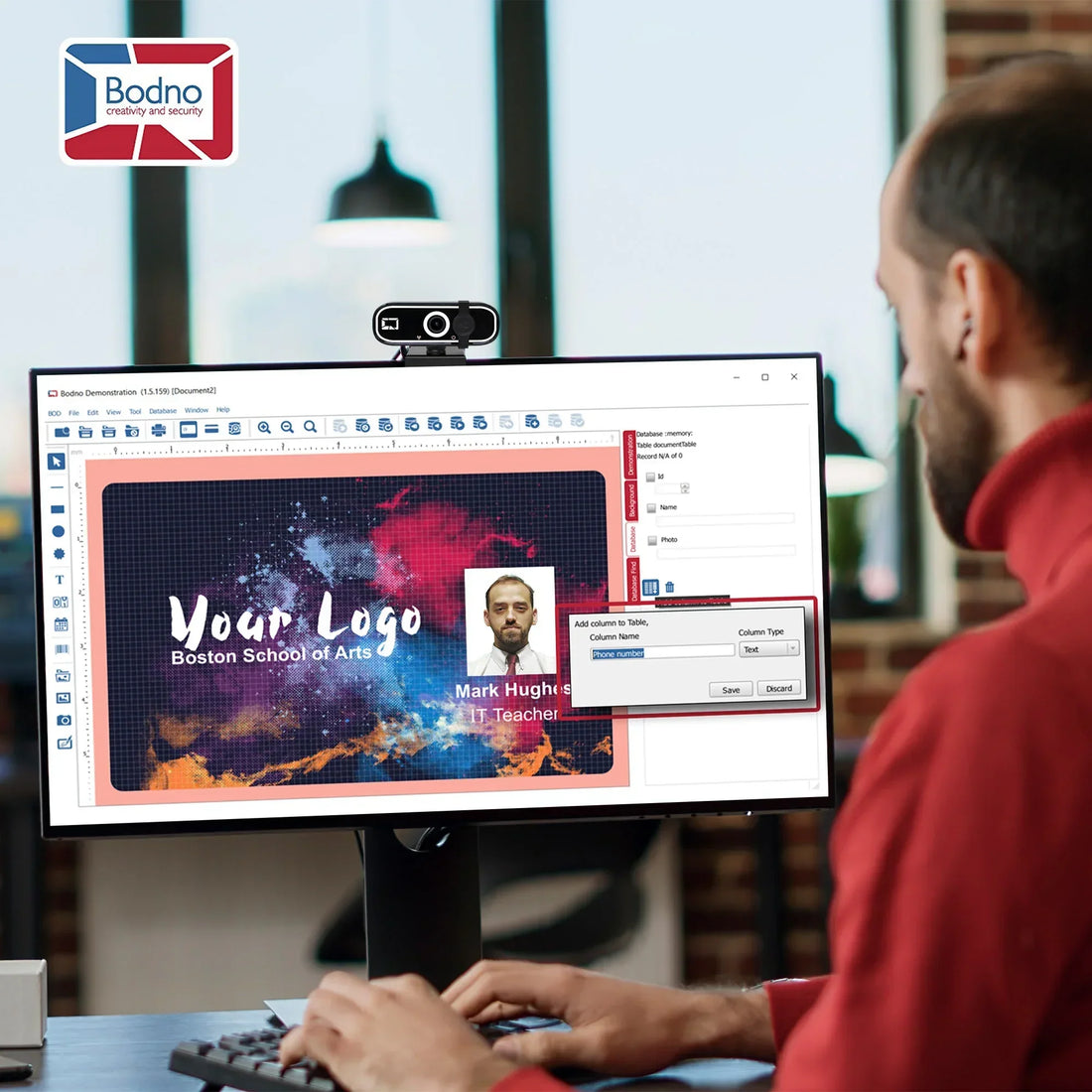 User designing ID card with photo and fields in Bodno software on desktop, webcam mounted above monitor